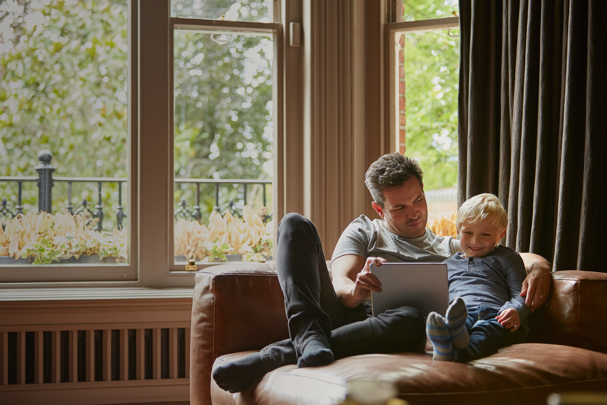 Shot of a father and his little son using a digital tablet together at home